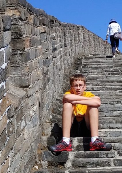 Boy sitting on the steps at the Great Wall of China