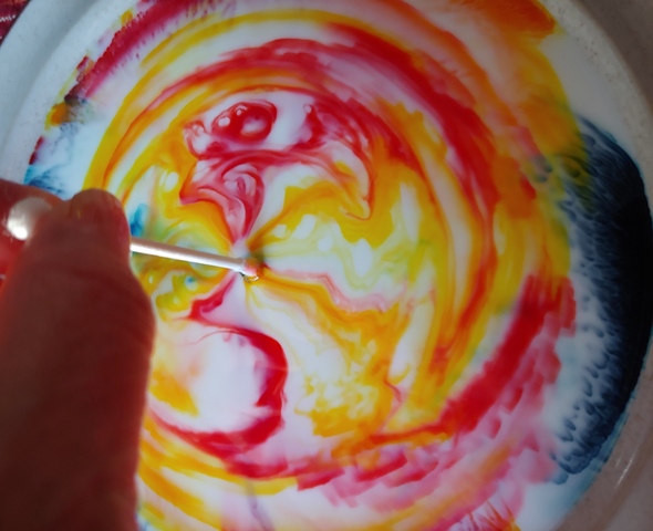 A Q-tip dipped into dish soap and then placed in the center of the plate of milk and food coloring creates a beautiful array of colors.