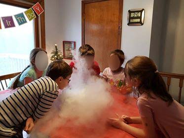 Playing with clouds of carbon dioxide vapor which is created when dry ice is added to hot water.