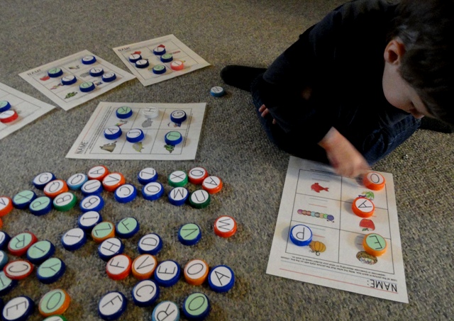 I like the creativity of chosing to homeschool. Here Andrew is learning letters and sounds using milk cap letters.