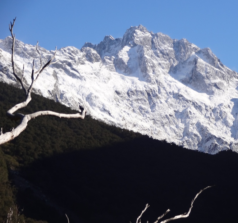 The snow cap mountains cast shadows over the valley.