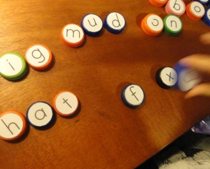  Spelling with glued alphabet letters on milk caps. 