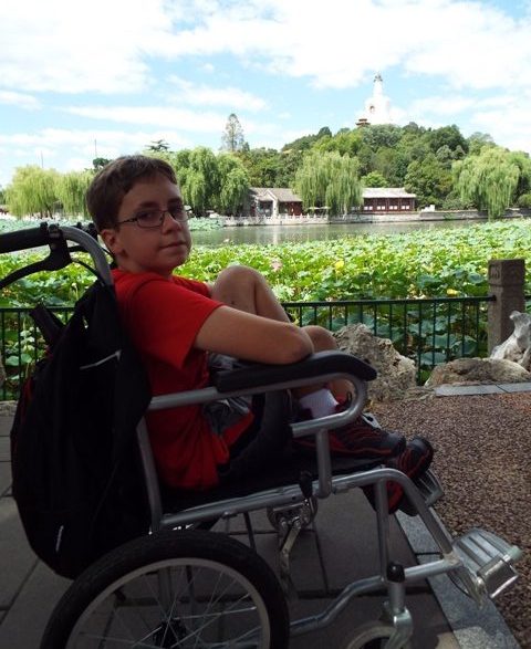 Boy in wheelchair at a Chinese garden.