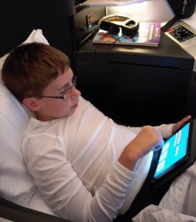 Boy on iPad in a recliner on airplane