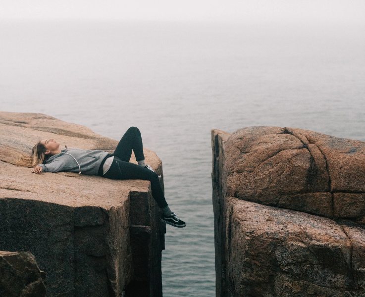 Woman exhausted on a cliff.