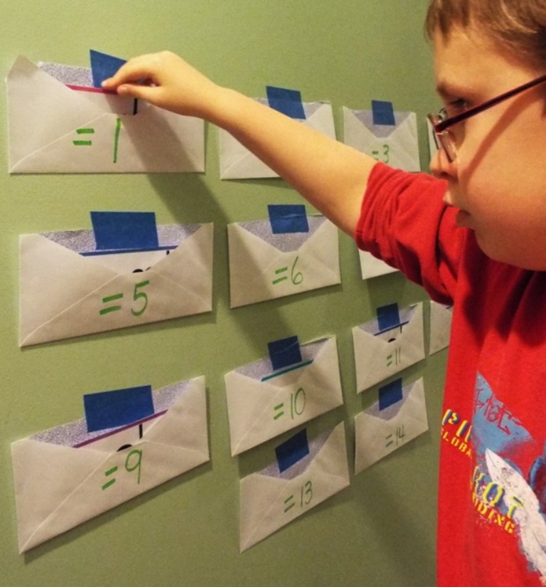 Boy sorting math flash cards into envelopes.