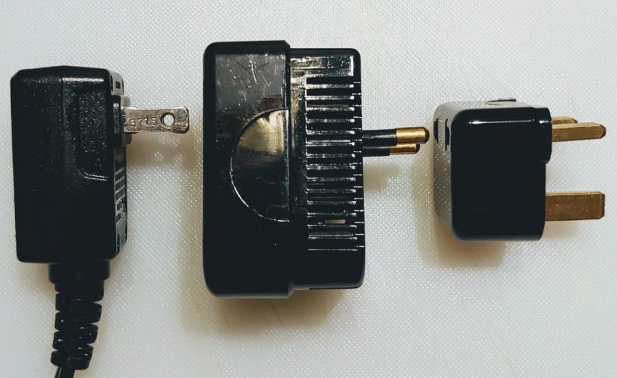 A US plug, converter and adapter ready to be plugged in.
