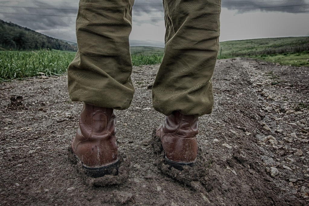 Muddy boots of hiker on trail