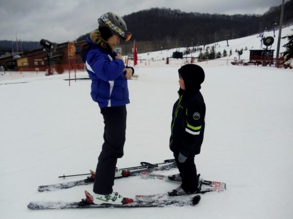Little boy and ski instructor