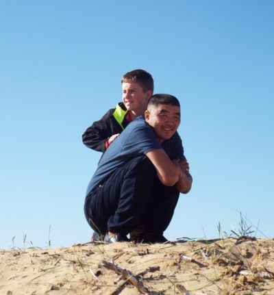 Two people on top of a sand dune