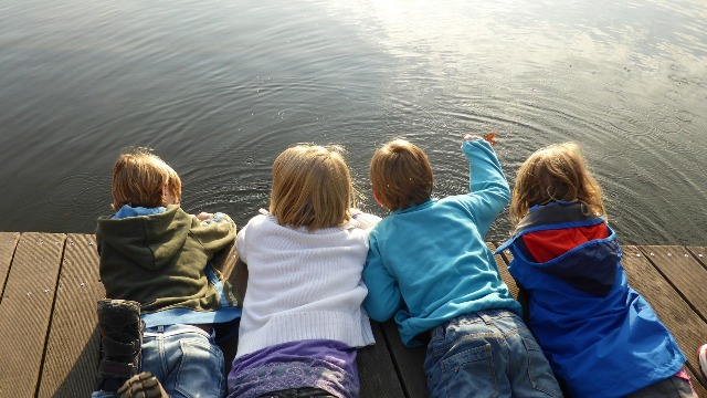 Children laying on a dock
