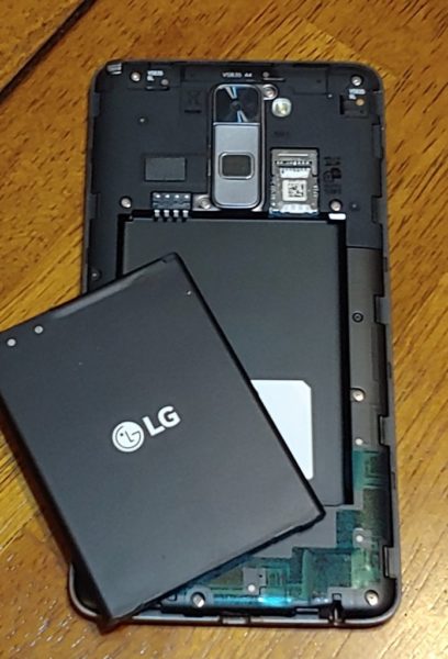 Removing the Android battery to access the SIM card.