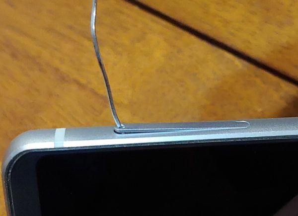 Use a paperclip to open a SIM card tray.